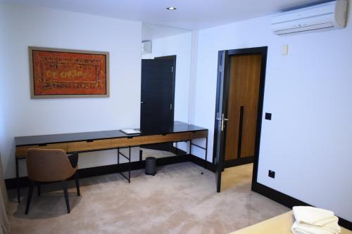 a room with a desk with a chair and a door at Hotel Sun Loznica in Loznica
