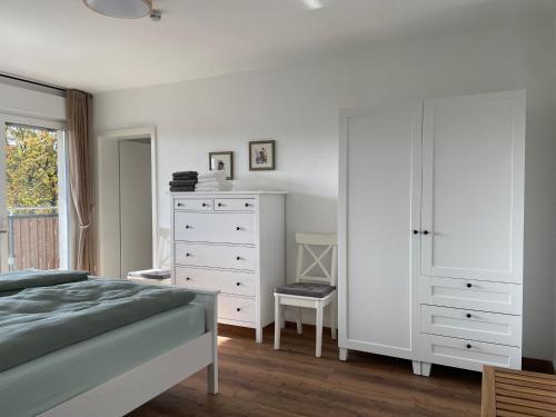 a bedroom with a bed and a white dresser at Gemütliche Gästewohnung, zentral, mit Blick in die Natur in Ennepetal