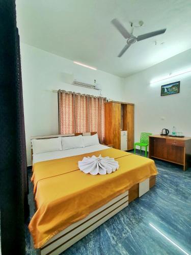 a bedroom with a large bed with a yellow blanket at kollam Beach Resort in Kollam