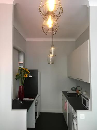 une cuisine avec un vase de fleurs sur un comptoir dans l'établissement Stunning apartment in the Gold Square of Nice!, à Nice