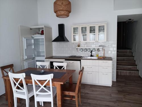 a kitchen with a wooden table and white cabinets at Dida Joja in Lički Osik