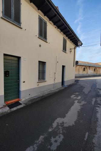 an empty street next to a building with a green garage at Diamante sul Mercato in Crema