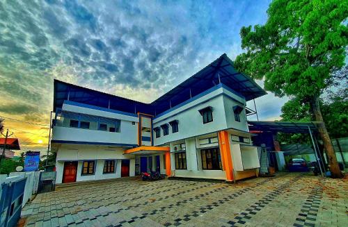 a large white house with a blue roof at kollam Beach Resort in Kollam