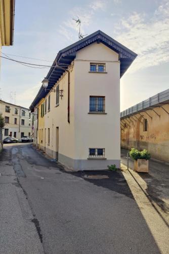 a white building with a black roof on a street at Diamante sul Mercato in Crema