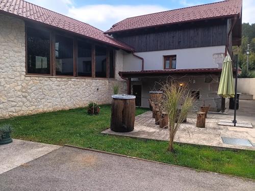 a house with a patio and an umbrella in the yard at Dida Joja in Lički Osik