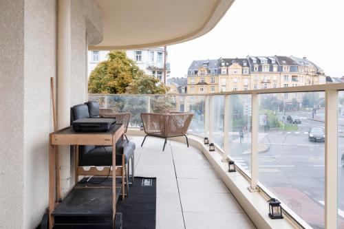 d'un balcon avec un bureau et une vue sur la rue. dans l'établissement Le Vigneulles, à Metz