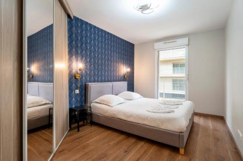 une chambre avec un lit et un miroir dans l'établissement Le Vigneulles, à Metz