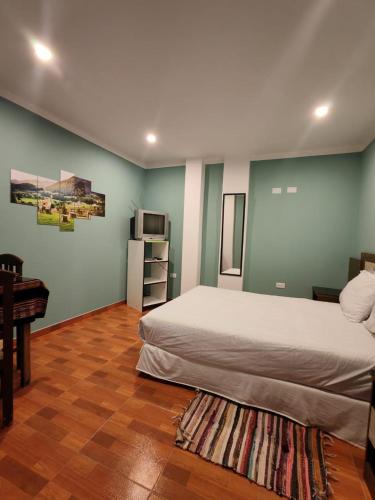 a bedroom with a bed and a table and a piano at Catag Wasi Casa hospedaje in Cajamarca