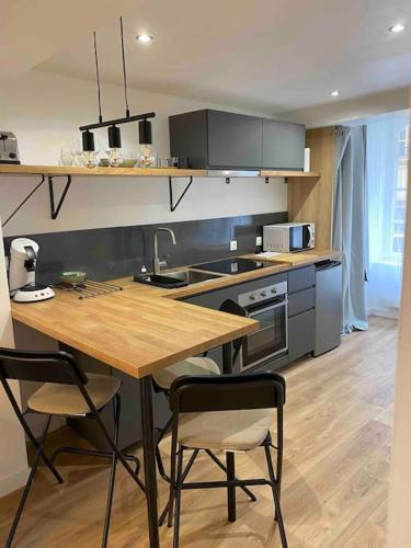 Il comprend une cuisine avec une table et des chaises en bois. dans l'établissement Studio centre historique Dinan, à Dinan