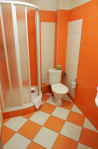 an orange and white bathroom with a toilet and shower at Penzion Relax Martina in České Budějovice