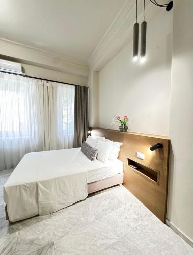 a bedroom with a large white bed and a window at OIKO MINI SUITES in Ermoupoli