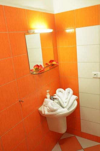 an orange bathroom with a sink and a mirror at Penzion Relax Martina in České Budějovice