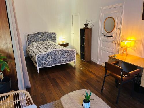 une chambre avec un lit, une table et un miroir dans l'établissement Chambre double au 1 er étage, à Saint-Maixent-lʼÉcole