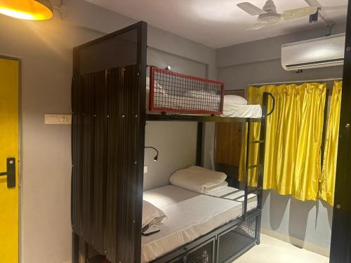 a room with two bunk beds in a room at Travotale Hostel and CoWork Koregaonpark Pune in Pune