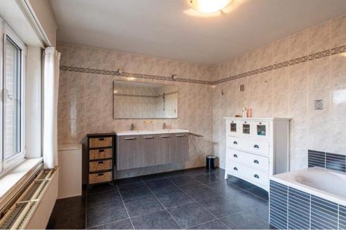 ein Badezimmer mit Badewanne und Waschbecken in der Unterkunft The Cozy Cottage in Eeklo