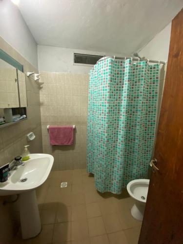 a bathroom with a shower curtain and a sink at La Mericia in Villa Carlos Paz