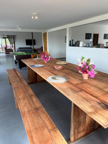 a large wooden table with flowers on top of it at Villa Chez Diarra in Saint-Louis