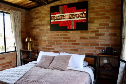 a bedroom with a bed and a brick wall at Molino de Café Cabañas Lodge in Chinchín Loma