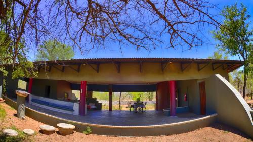 a small house with a patio in the middle at Tingala Lodge - Bed in the Bush in Phalaborwa