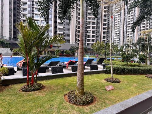 two palm trees and a pool in a building at TheBess Hotel Tokyo is located adjacent to Singapore and offers a sea viewIt is a family business smart room with the sea view of Princess Bay富力公主湾 in Johor Bahru