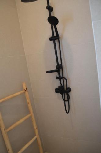a black towel rack on a wall next to a ladder at Appartement chic et beldi à 10 minutes du centre in Essaouira