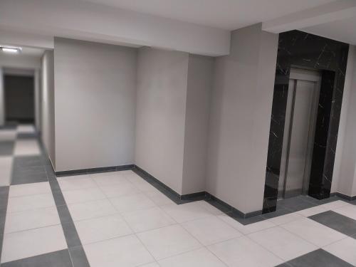a empty room with white walls and a tile floor at Apartament Poleska in Częstochowa