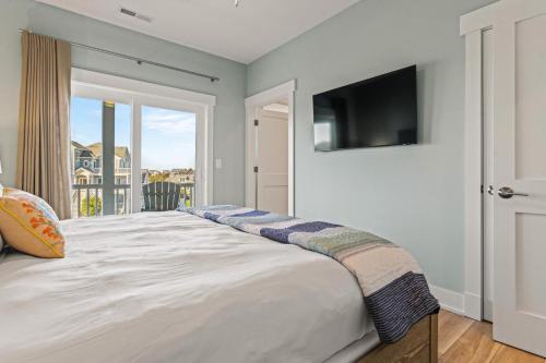 a bedroom with a large bed with a tv on the wall at Summer Salt 10 Bedroom Home at Hattie Creef Landing in Salvo