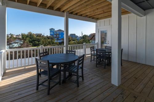 a porch with a table and chairs on a deck at Summer Salt 10 Bedroom Home at Hattie Creef Landing in Salvo