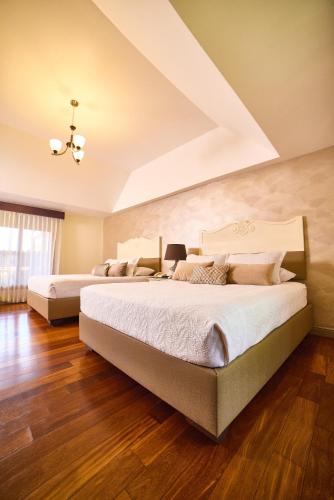 two beds in a room with wood floors at El Rodeo Estancia Boutique Hotel & Steakhouse in San José