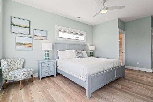a bedroom with a bed and a chair at Summer Salt 10 Bedroom Home at Hattie Creef Landing in Salvo