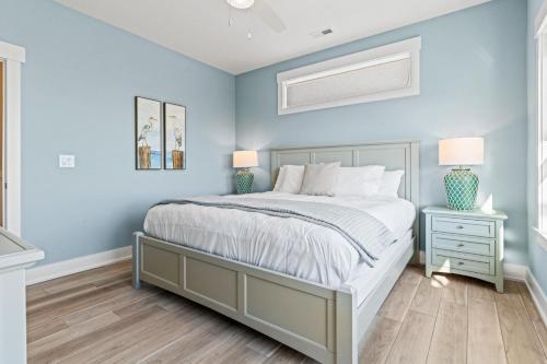 a bedroom with blue walls and a bed and two lamps at Summer Salt 10 Bedroom Home at Hattie Creef Landing in Salvo