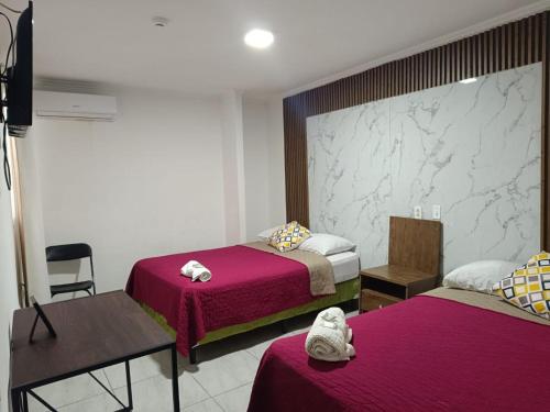 a hotel room with two beds and a table and chairs at Express Inn PTY Aeropuerto Internacional Panama in Tocumen