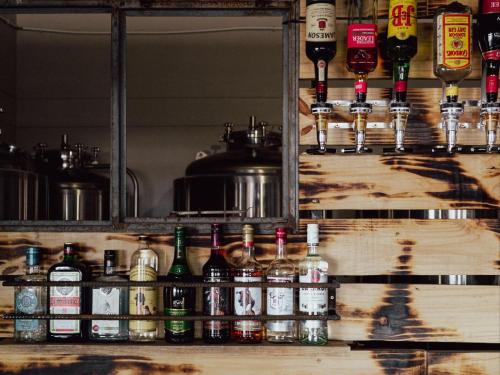 a bar with a bunch of bottles of alcohol at Stofpad Lodge and Camping in Guisis