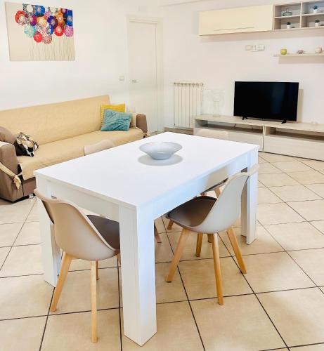 a white table and chairs in a living room at Serao House, 2 piano in centro in Mondragone
