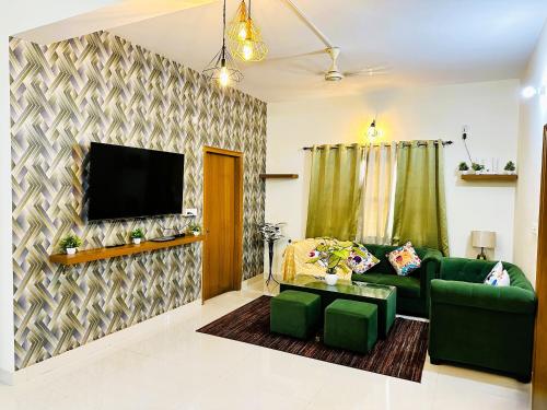 a living room with a green couch and a flat screen tv at ZoomStay - 3BHK Apartments in Varanasi