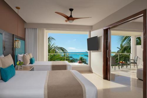 a bedroom with a bed and a view of the ocean at Dreams Jade Resort & Spa - All Inclusive in Puerto Morelos