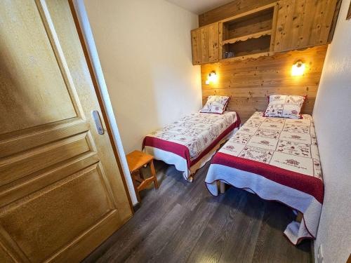 a small room with two beds and a door at Appartement confort 5 pers. Les Menuires avec balcon, casiers à skis, 2 chambres - FR-1-452-248 in Les Menuires