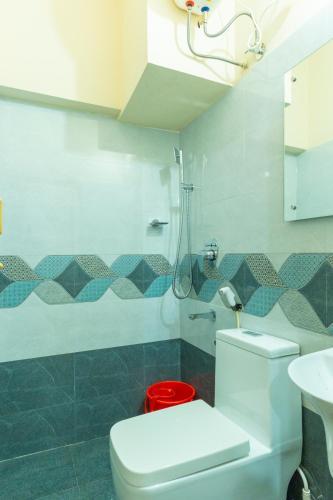 a bathroom with a toilet and a sink and a shower at Be My Guest in Kozhikode