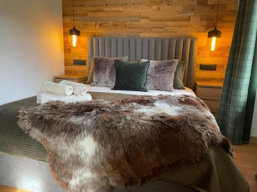 - une chambre avec un grand lit et une couverture en fourrure dans l'établissement Chalet OurSourie, à Saint-Gervais-les-Bains