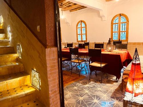 a dining room with tables and chairs in a building at Auberge La Fibule Du Dades in Aït Idaïr