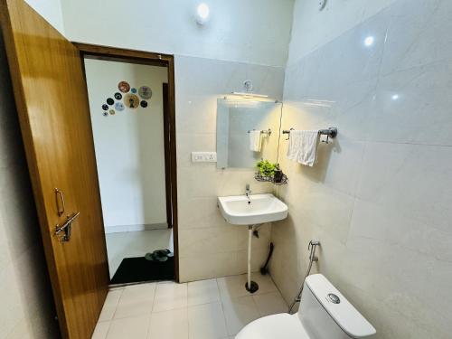 a bathroom with a toilet and a sink at ZoomStay - 3BHK Apartments in Varanasi