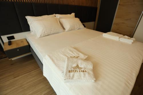 a large white bed with a bag on it at Hotel Luna in Prizren