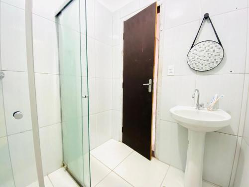 a bathroom with a sink and a glass shower door at Casa Bela Vista in Lençóis