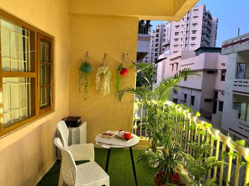 a balcony with a table and chairs and plants at ZoomStay - 3BHK Apartments in Varanasi