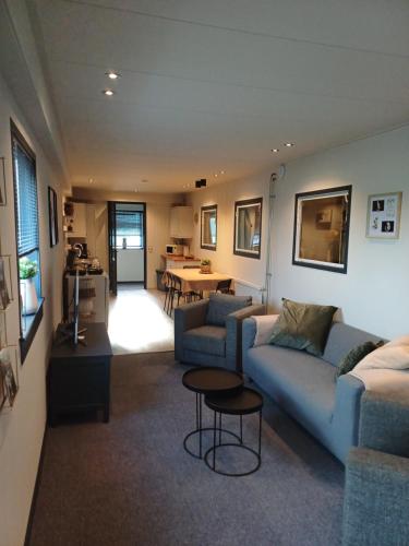 a living room with a couch and a table at Boerderij Appartement Jachtlust in Voorhout