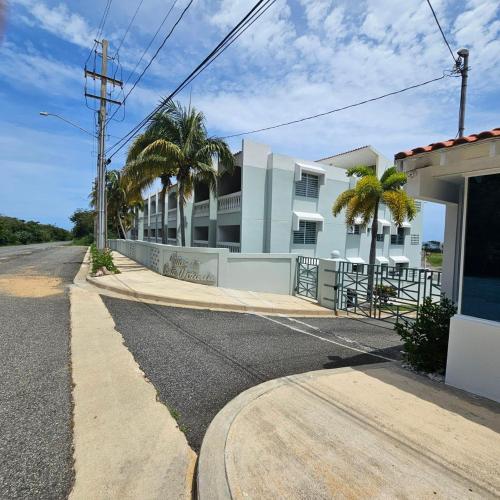 an empty street in front of a building with palm trees at Golden Villas 306 studio in Isabela