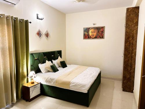 a bedroom with a bed with a green headboard at ZoomStay - 3BHK Apartments in Varanasi