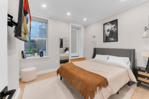 a bedroom with a bed and a tv and a window at Modern 3Bd Rose Hills Manhattan Terrace Space in New York