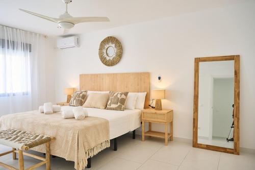 una camera da letto bianca con un letto grande e uno specchio di Villa Carmen Albir a Albir