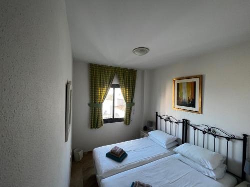 una camera da letto con due letti e una finestra di 3 Bed Beachfront Penthouse 854 with great views a Manilva
